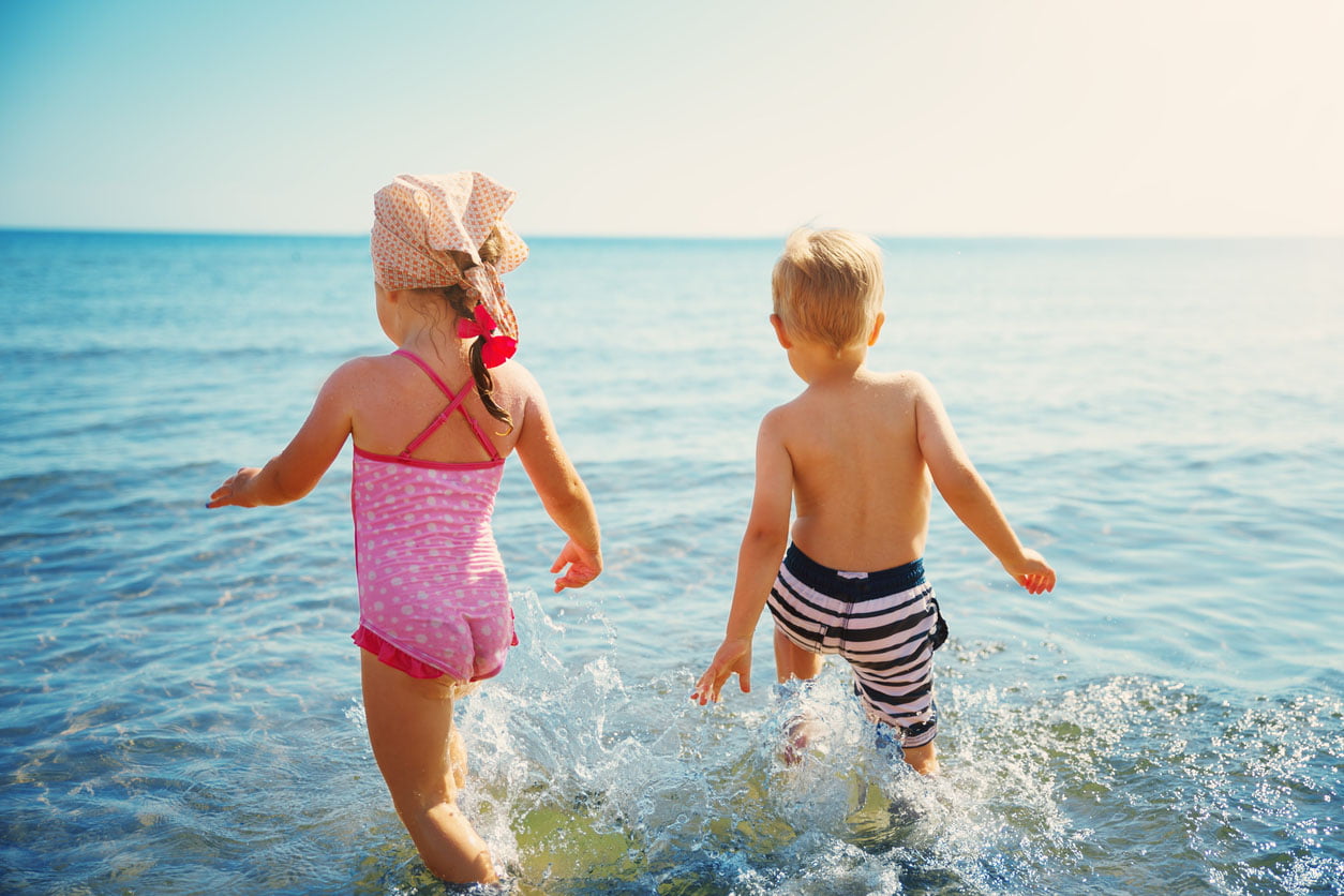 Garçon et fille jouant sur la plage sur des vacances d’été