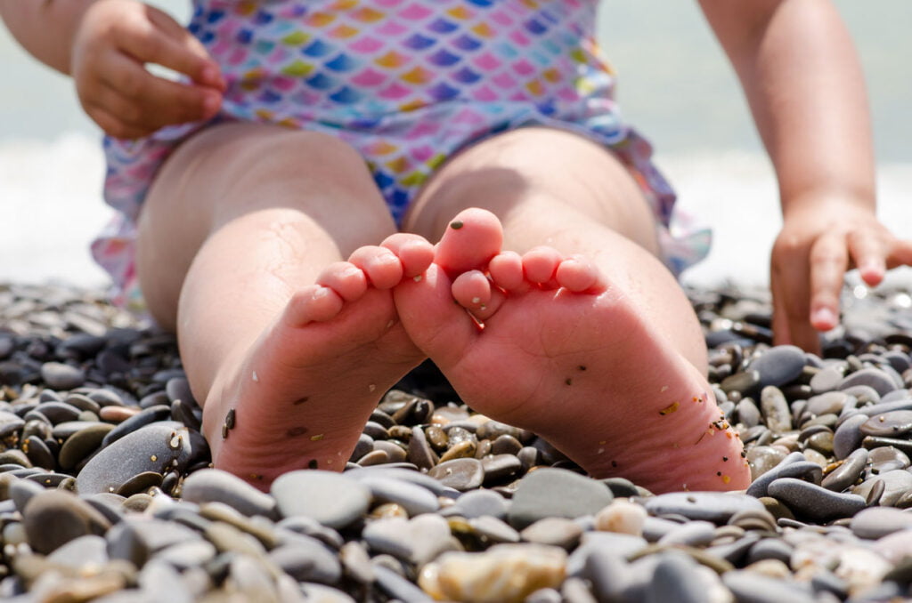 nfant de 5 ans joue avec des cailloux sur une plage de sable par une journée ensoleillée au bord de la mer 