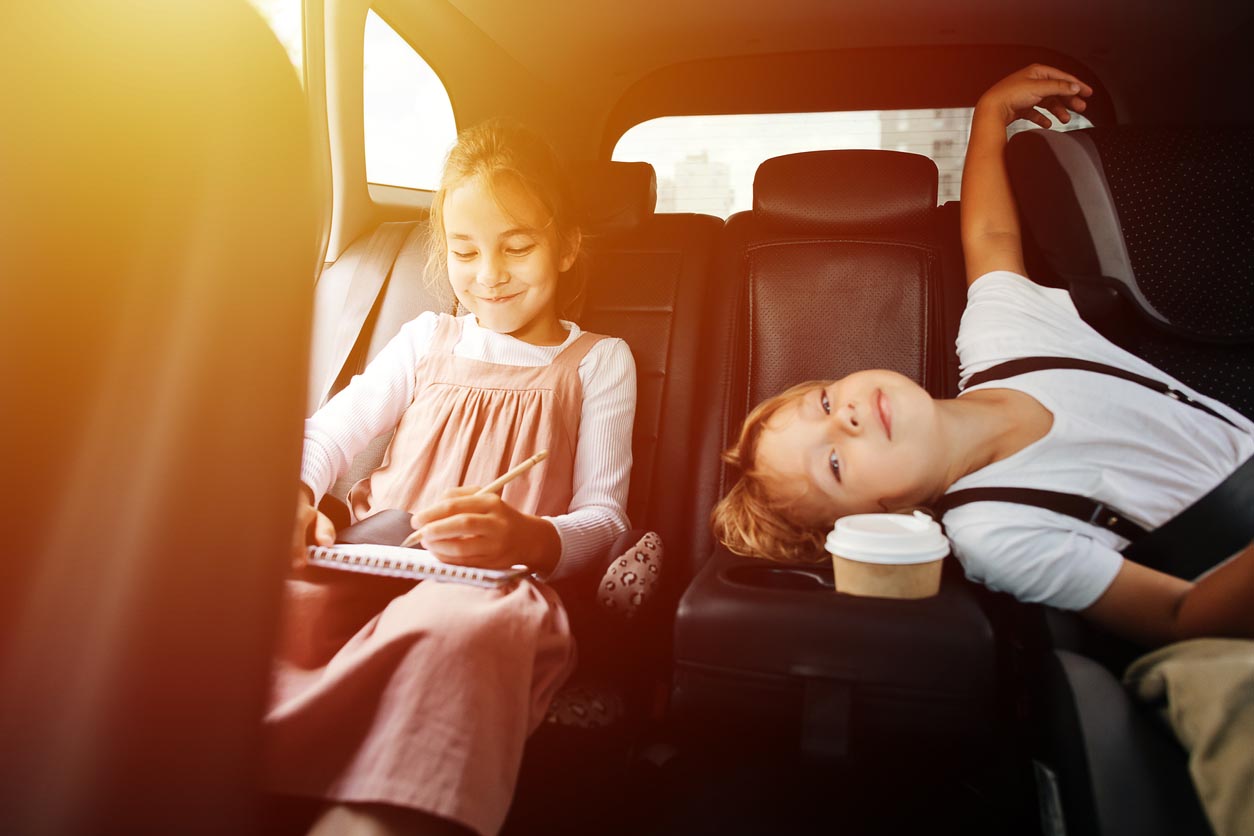 petite fille dessine dans la voiture avec son petit frere
