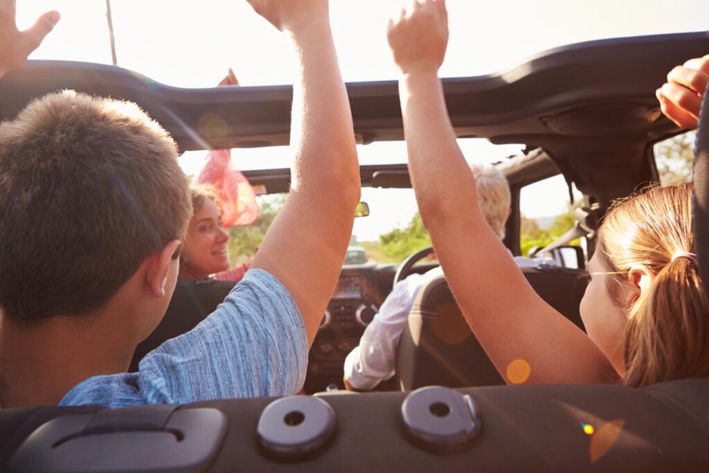parents profitant de leurs enfants sur voiture voyage à toit ouvert