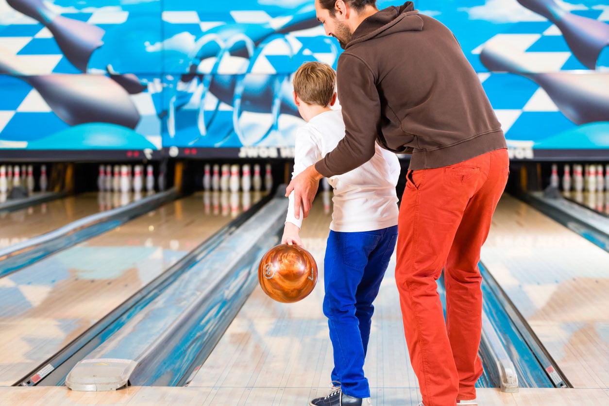 Père et fils jouer au bowling