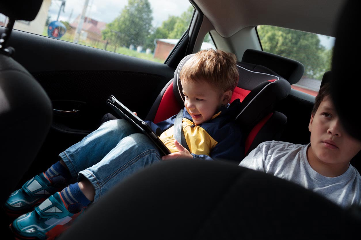 Deux garçons sur le siège arrière de voiture regarde un film sur tablette