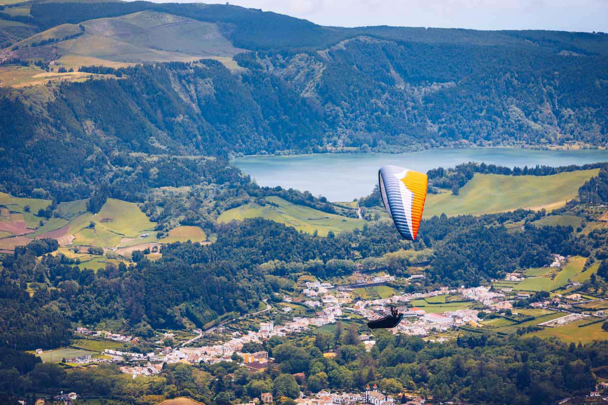 Parapente dans un paysage paradisiaque avec cratère de volcan et lagon aux Açores