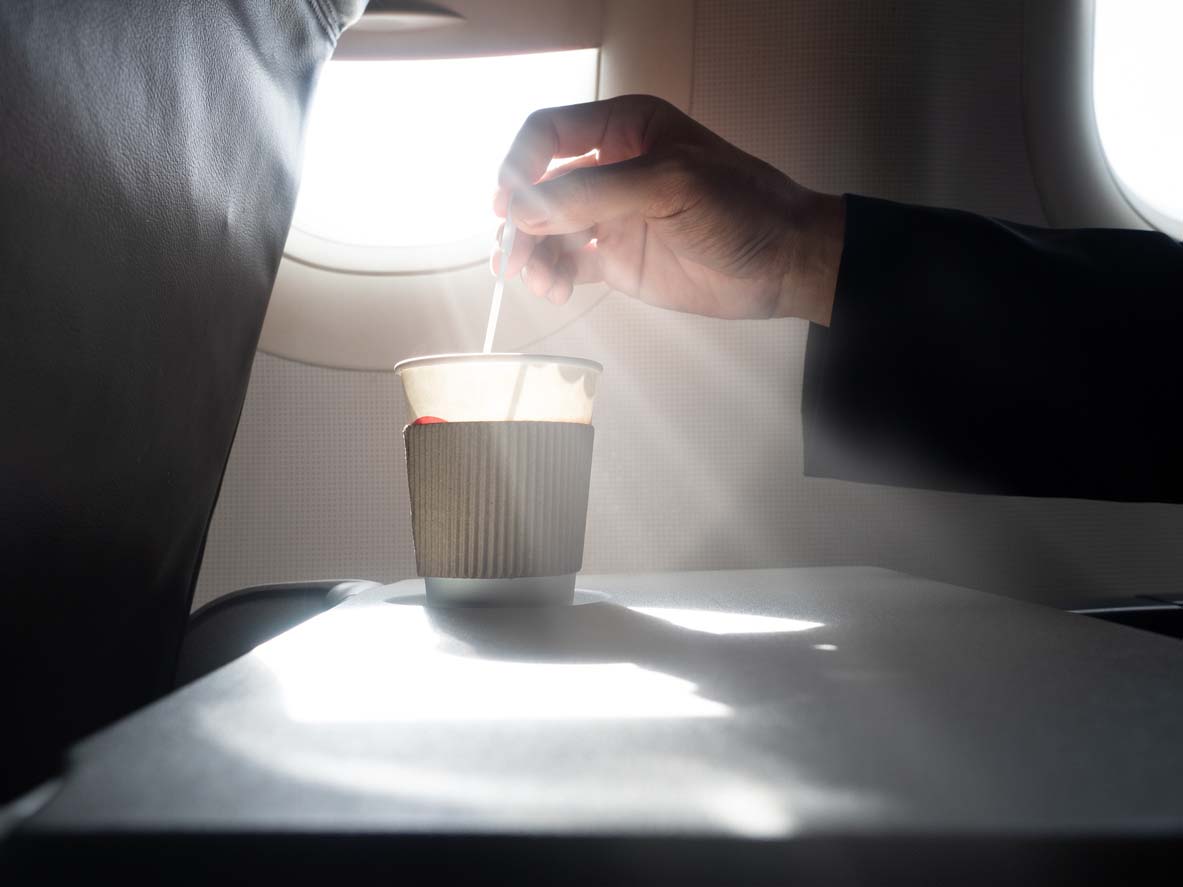 Homme avec un café à l'intérieur de l'avion