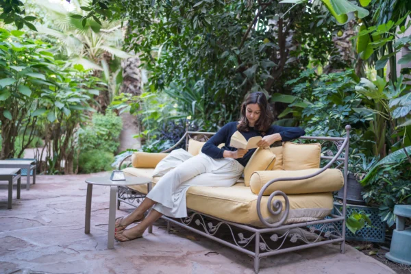 Une jeune dame se relaxant sur un canapé tout en lisant un livre