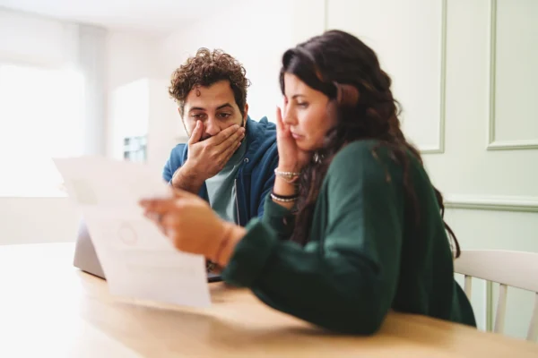un Homme et une femme regardant une facture d'électricité