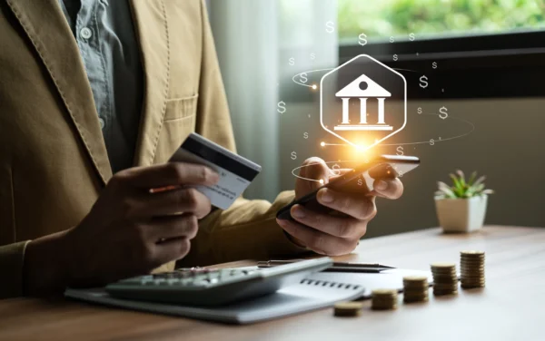 Homme tenant un carte bancaire entre ses mains et faisant des transactions en ligne